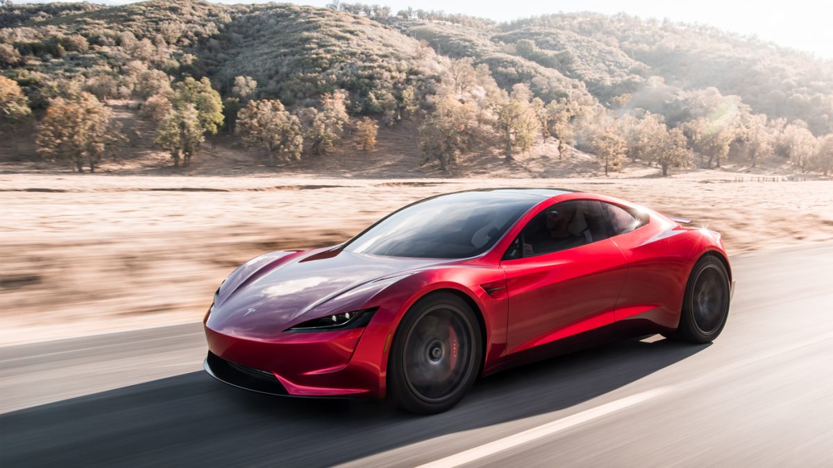 Tesla Roadster vermelho de frente andando na estrada 