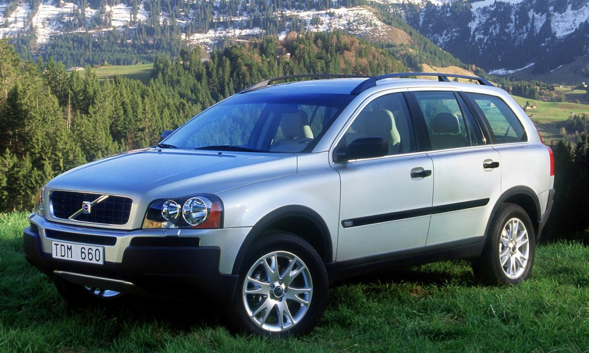 Carro Volvo XC90 parado de frente com árvores ao fundo