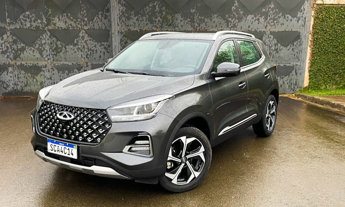 CAOA Chery Tiggo 5X Pro cinza parado de frente com muro de cimento ao fundo