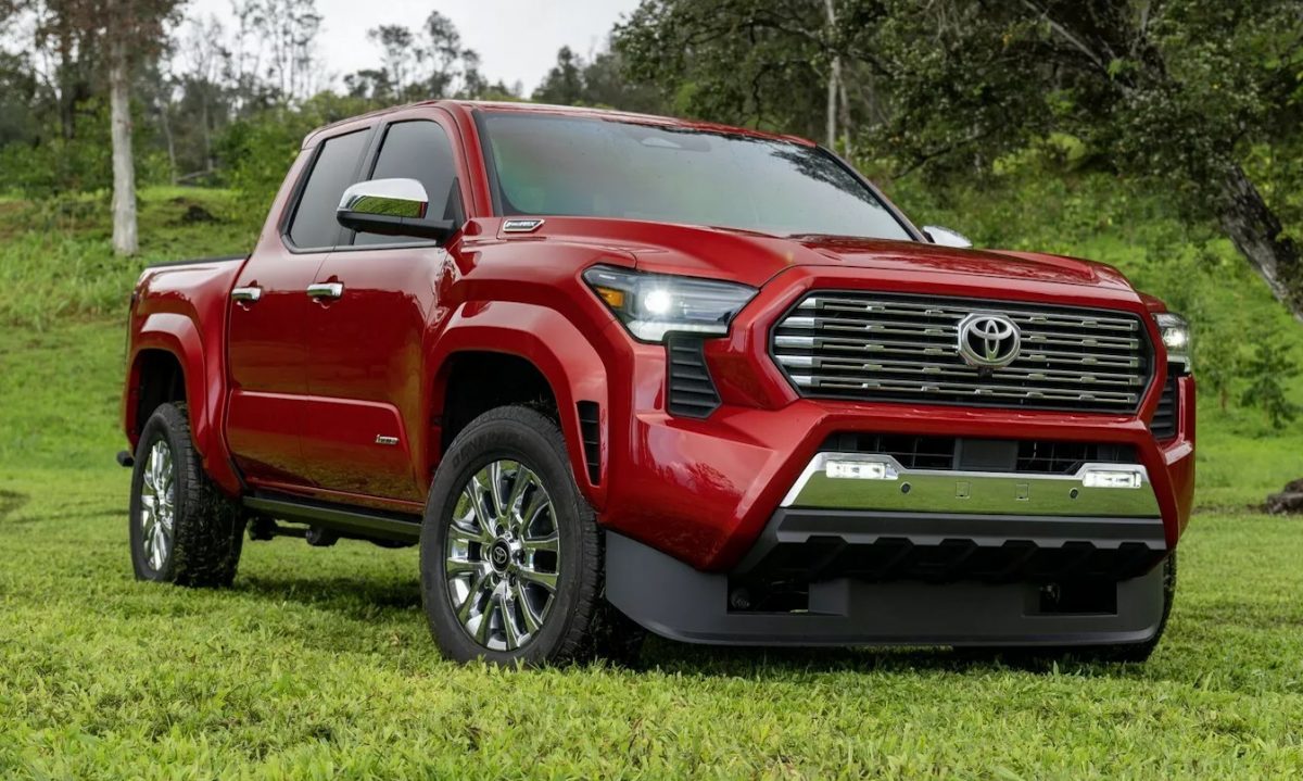 Toyota Tacoma 2024 vermelha parada na grama com árvores ao fundo  [divulgação]
