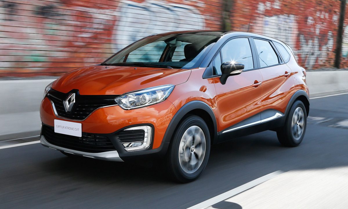 Renault Captur laranja de frente andando na cidade