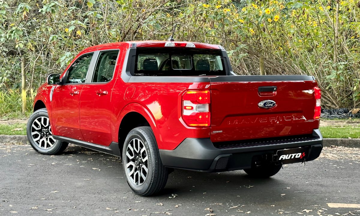 Ford Maverick Hybrid vermelha parada de traseira com árvores ao fundo