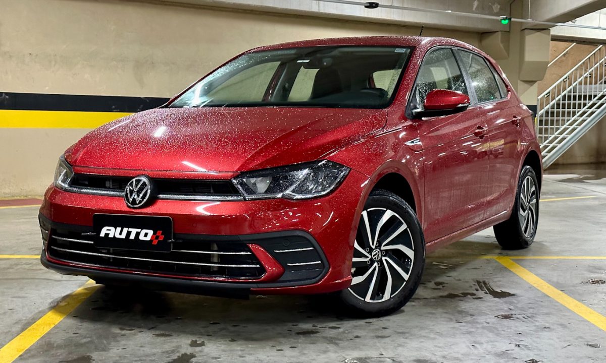 Volkswagen Polo Highline vermelho de frente em um estacionamento todo molhado