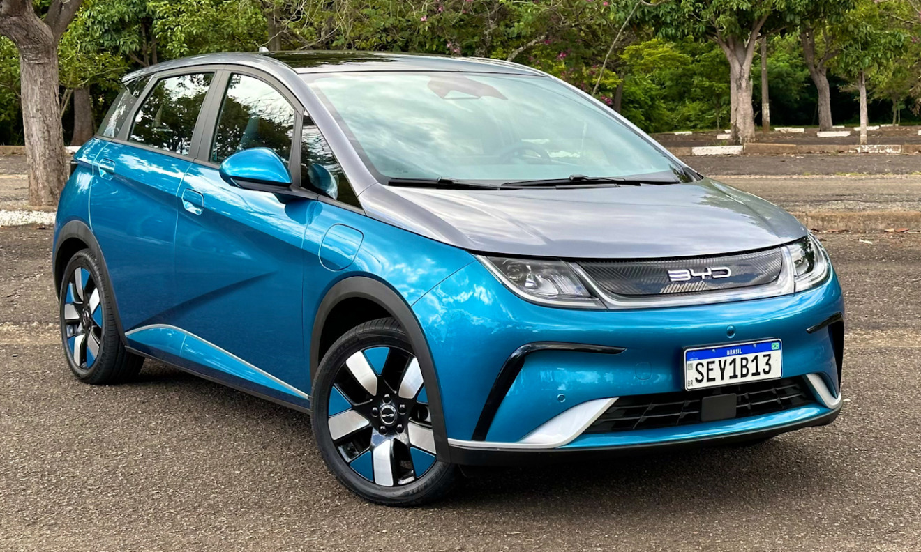 BYD Dolphin Plus parado de frente no asfalto com a carroceria pintada em duas tonalidades