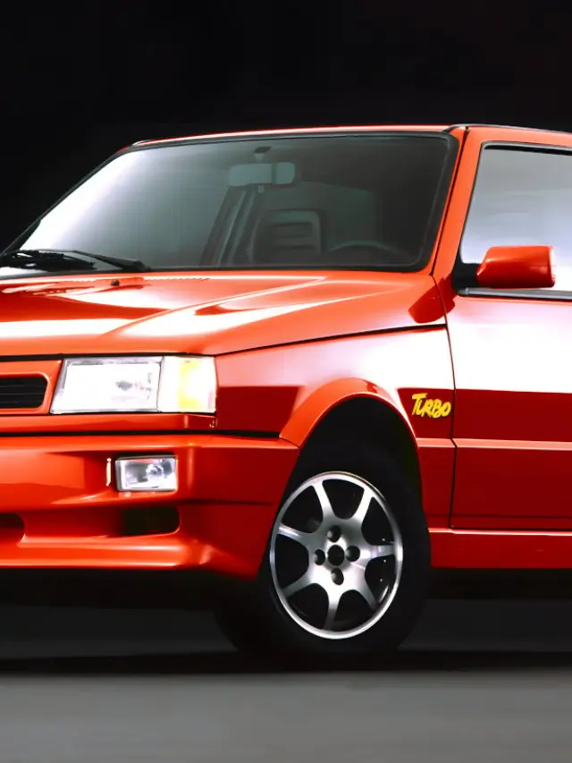 Fiat Uno Turbo vermelho parado de dianteira com fundo preto