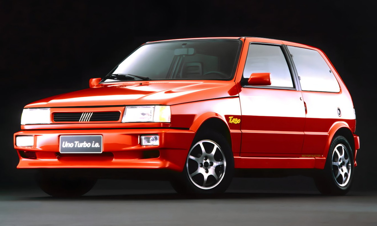  Fiat Uno Turbo vermelho parado de dianteira com fundo preto é um dos carros mais legais da Fiat 