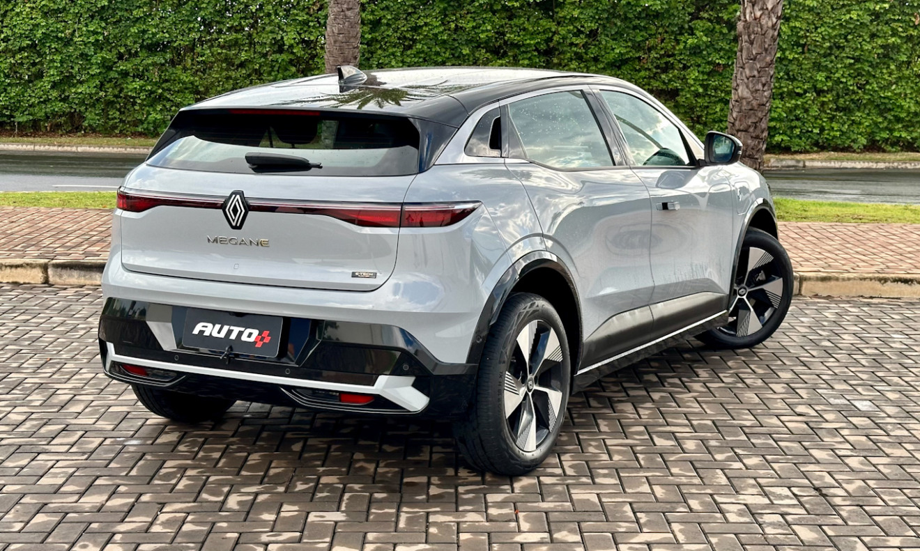 Renault Megane E-Tech prata estacionado de traseira com árvores ao fundo