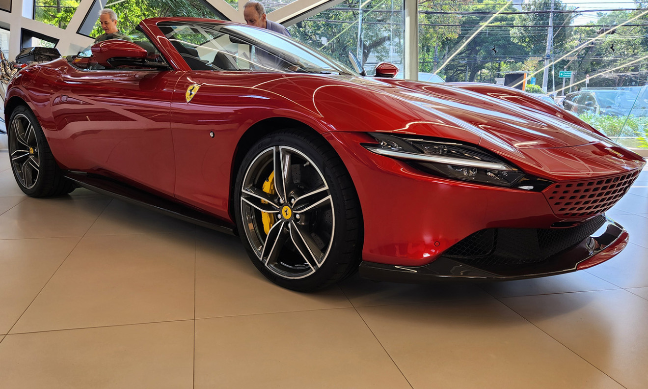 Ferrari Roma Spider vermelha parda dentro da concessionária