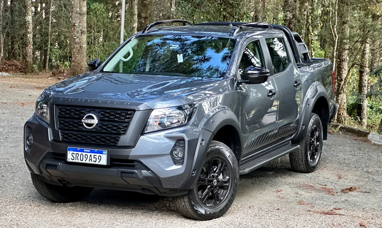 Nissan Frontier Attack cinza de frente com uma floresta ao fundo