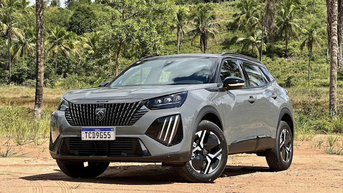 Peugeot 2008 GT cinza parado de frente com árvores ao fundo