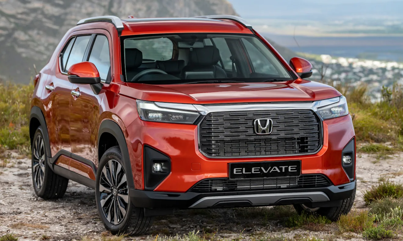 Honda WR-V laranja parado de frente com montanhas ao fundo