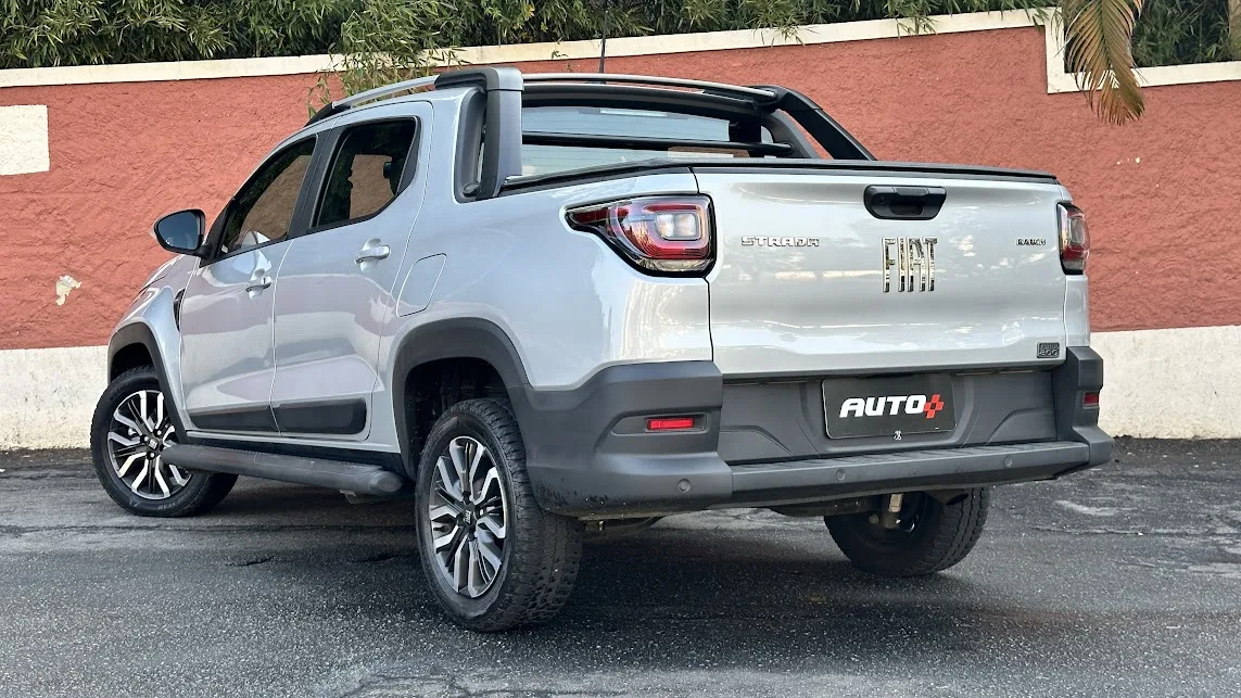 Fiat Strada Ranch prata estacionada de traseira em frente a um muro laranja e branco