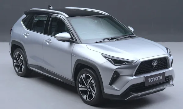 Toyota Yaris Cross prata parado de lateral com o chão e fundo em cinza
