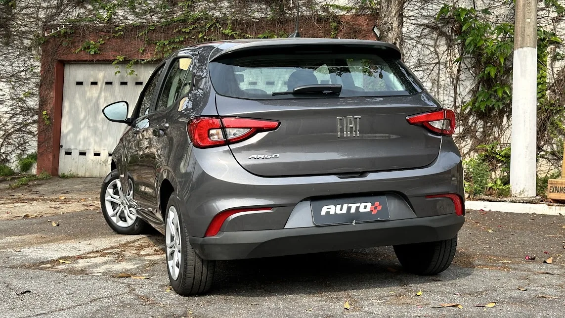 Fiat Argo cinza parado de traseira em frente a um portão