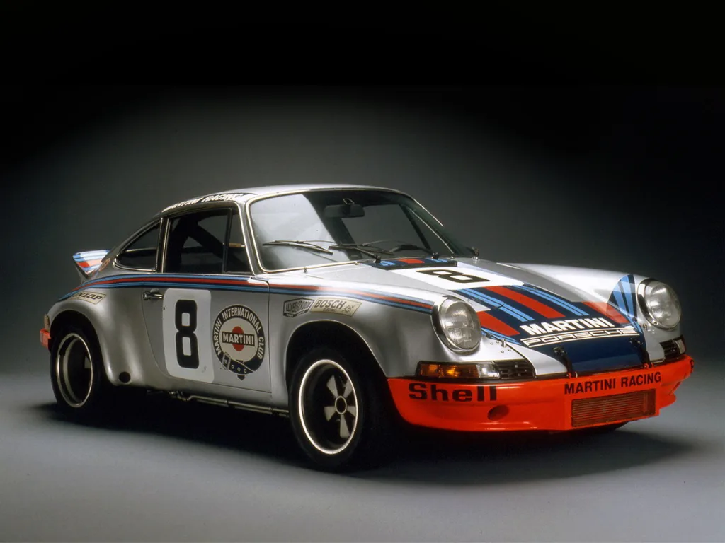 Porsche 911 RSR Martini Racing em foto estática com chão cinza e fundo preto - Curiosidades sobre carros