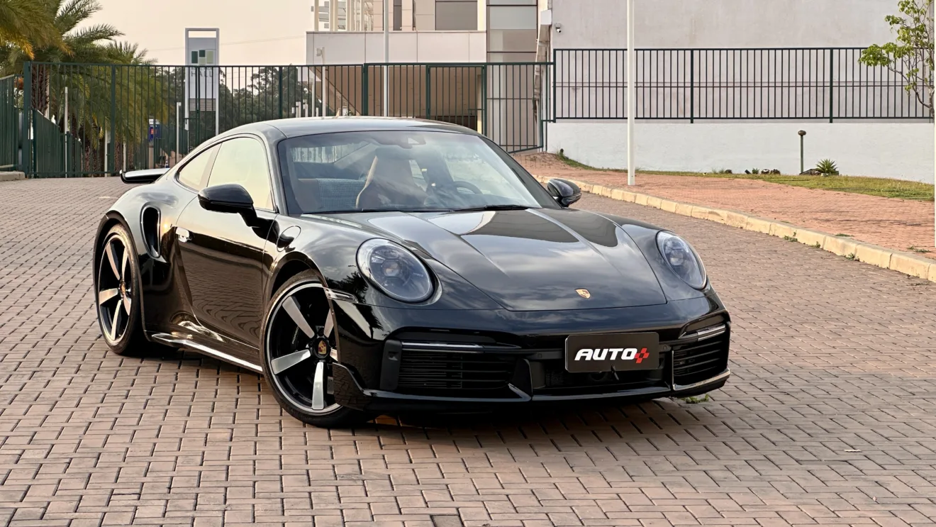 Porsche 911 Turbo preto em frente a um hotel em um por do sol
