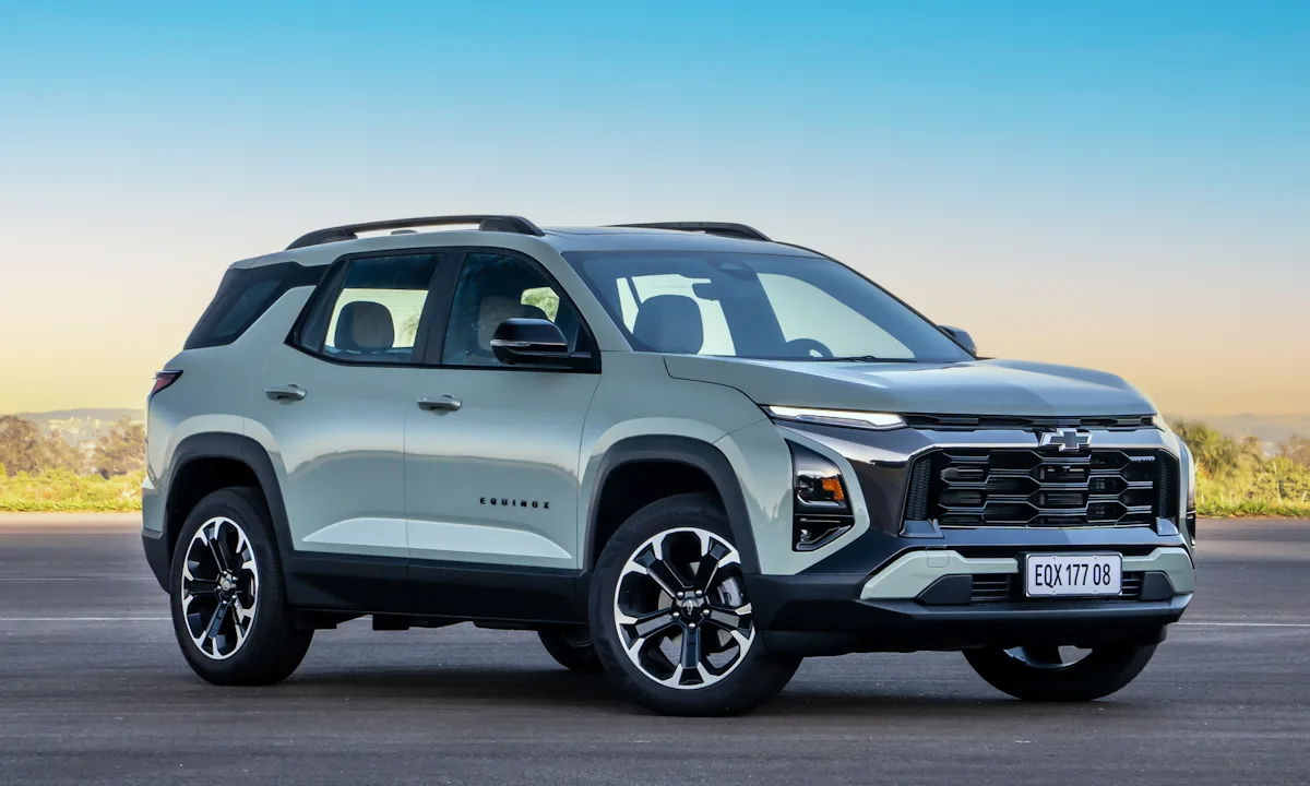 Chevrolet Equinox Activ 2025 verde parado de frente em um por do sol