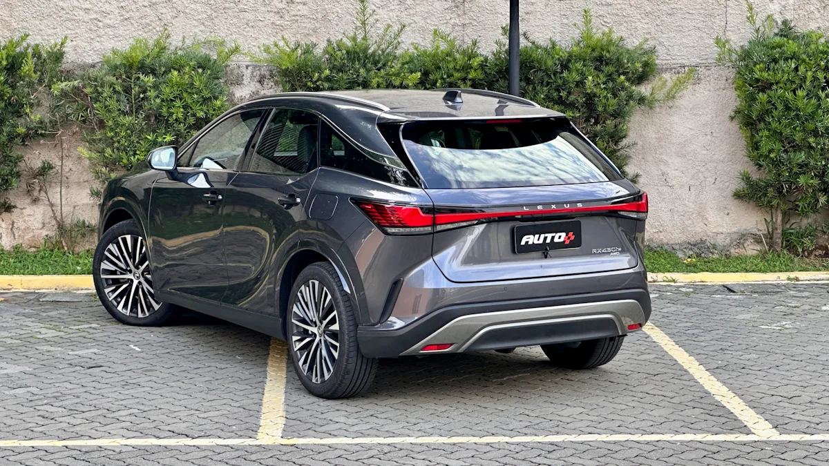 Lexus RX450h cinza de traseira em um estacionamento com um muro de plantas atrás. Marca de luco japonesa batiza os modelos com siglas alfanuméricas