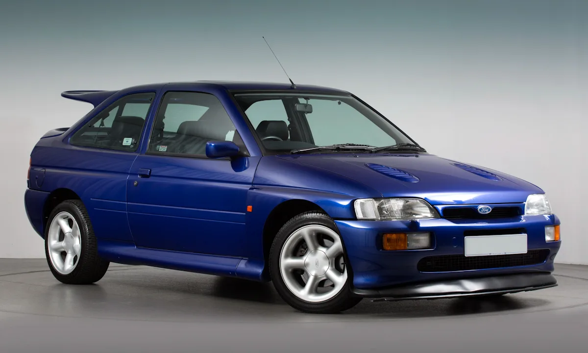Ford Escort RS Cosworth azul parado de frente foi um carro equipado com o grande aerofólio montado na traseira 