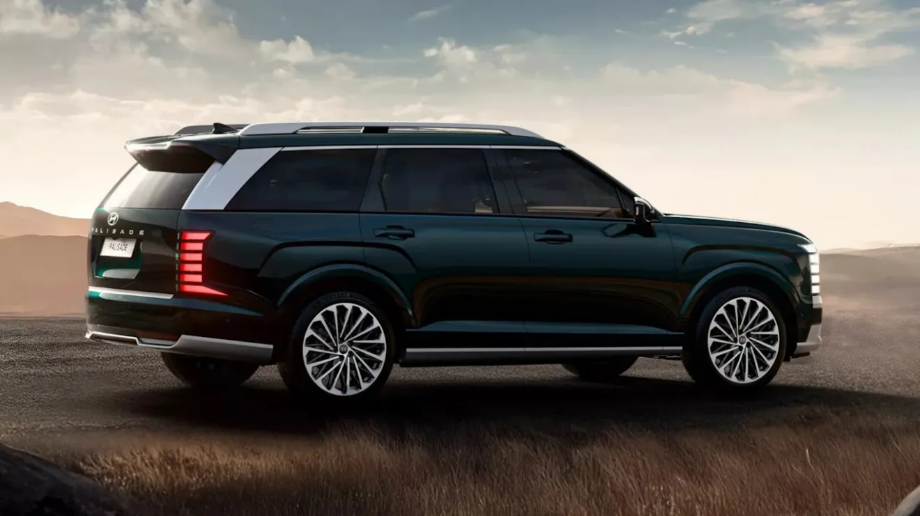 Vista de trás do novo Hyundai Palisade cinza escuro, com lanternas acesas e fundo claro