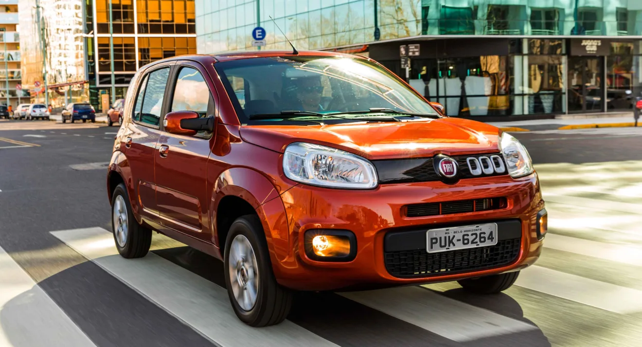 Fiat Uno Evolution laranja andando na cidade foi o primeiro carro popular equipado com Start-Stop