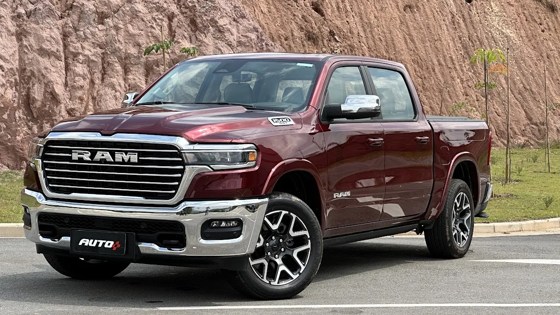 Ram 1500 Laramie vermelha parada de frente com morro ao fundo