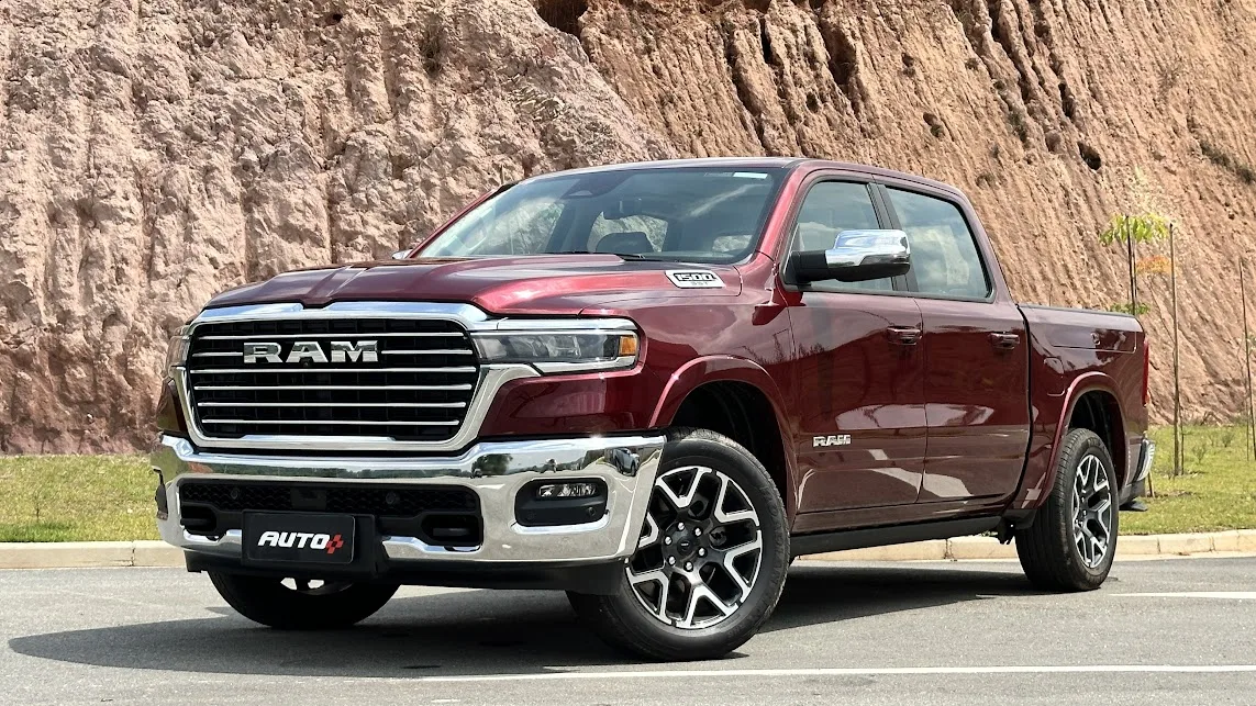 Ram 1500 Laramie vermelha com para-choques cromados de frente com um fundo de terra