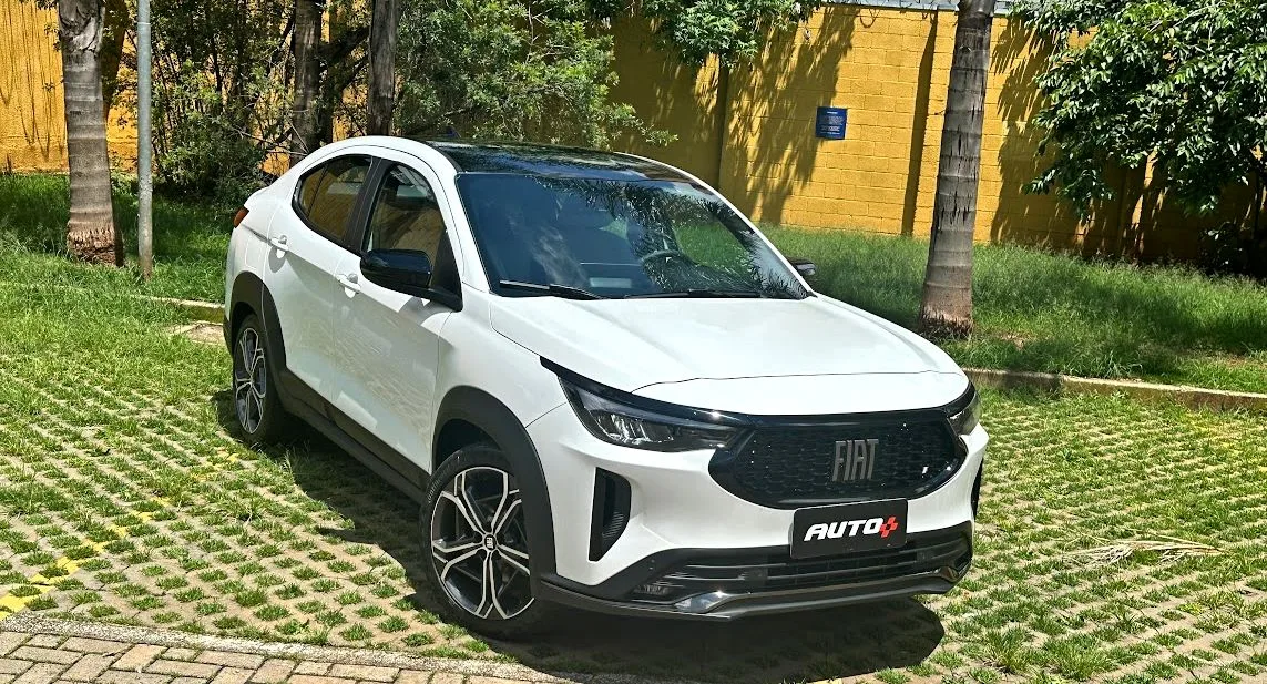 Fiat Fastback Impetus T200 Hybrid branco parado de frente com muro amarelo e árvores ao fundo