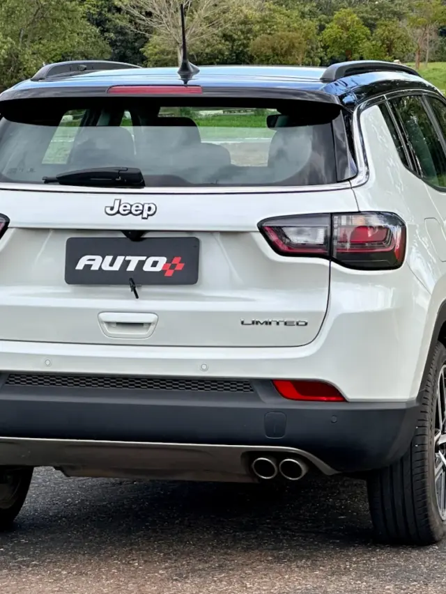 Jeep Compass Limited flex branco com teto preto parado de traseira em um estacionamento