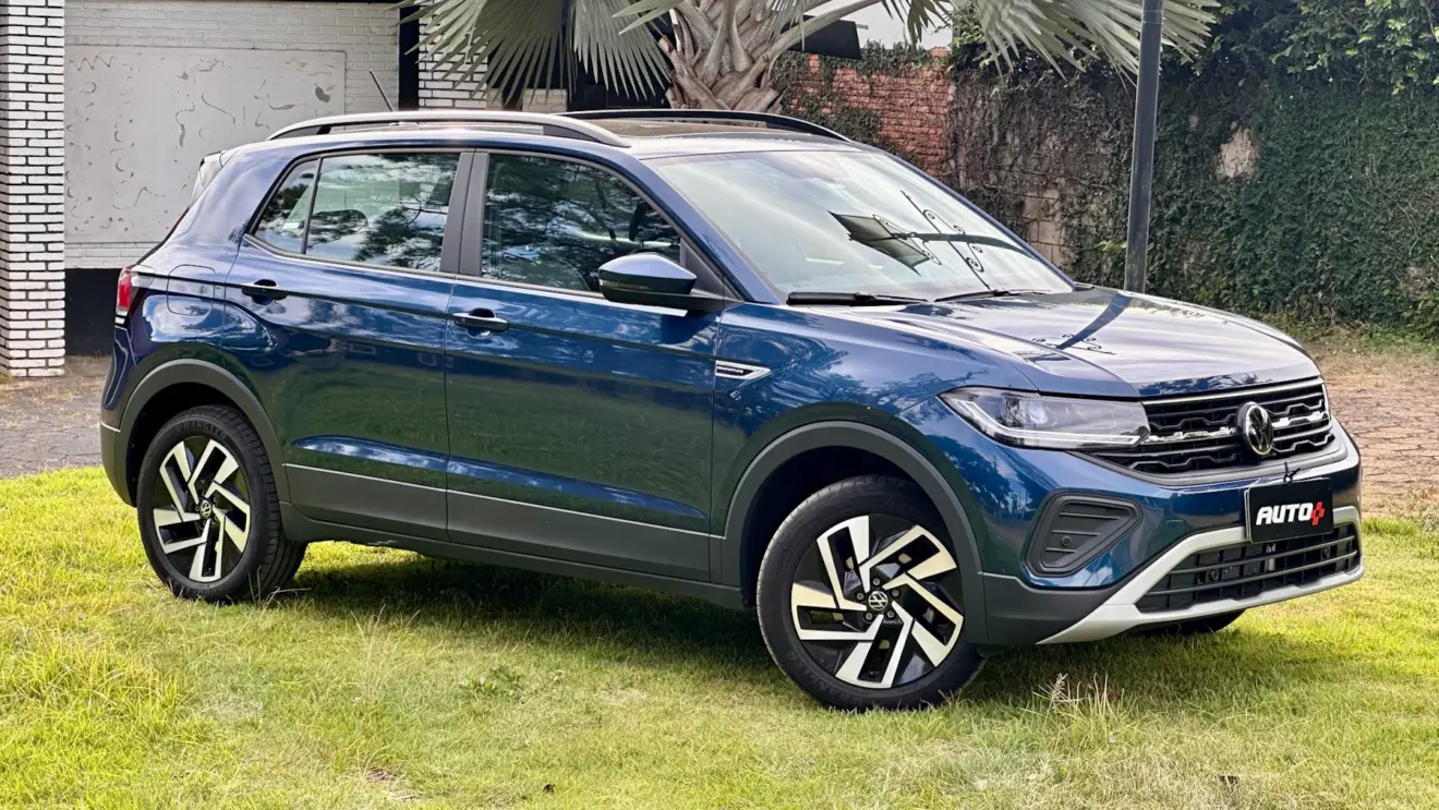 Volkswagen T-Cross Comfortline azul de frente em um gramado com uma casa ao fundo