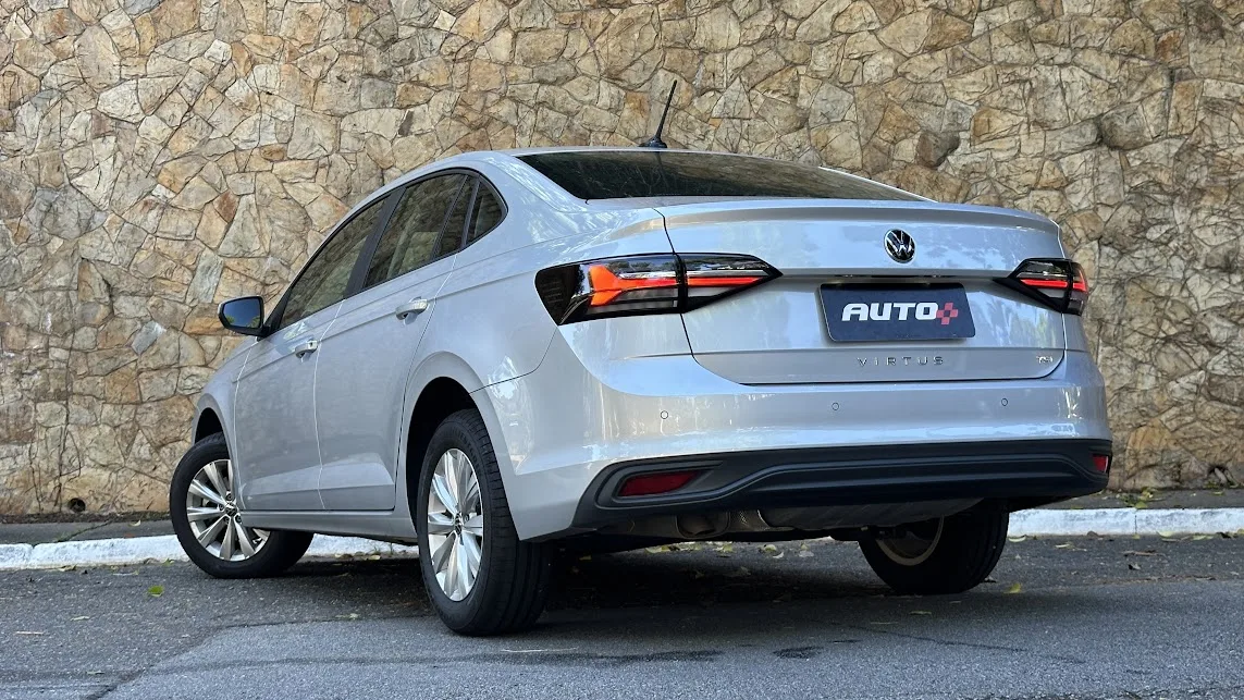 Volkswagen Virtus 170 TSI prata estacionado de traseira com muro de pedras ao fundo