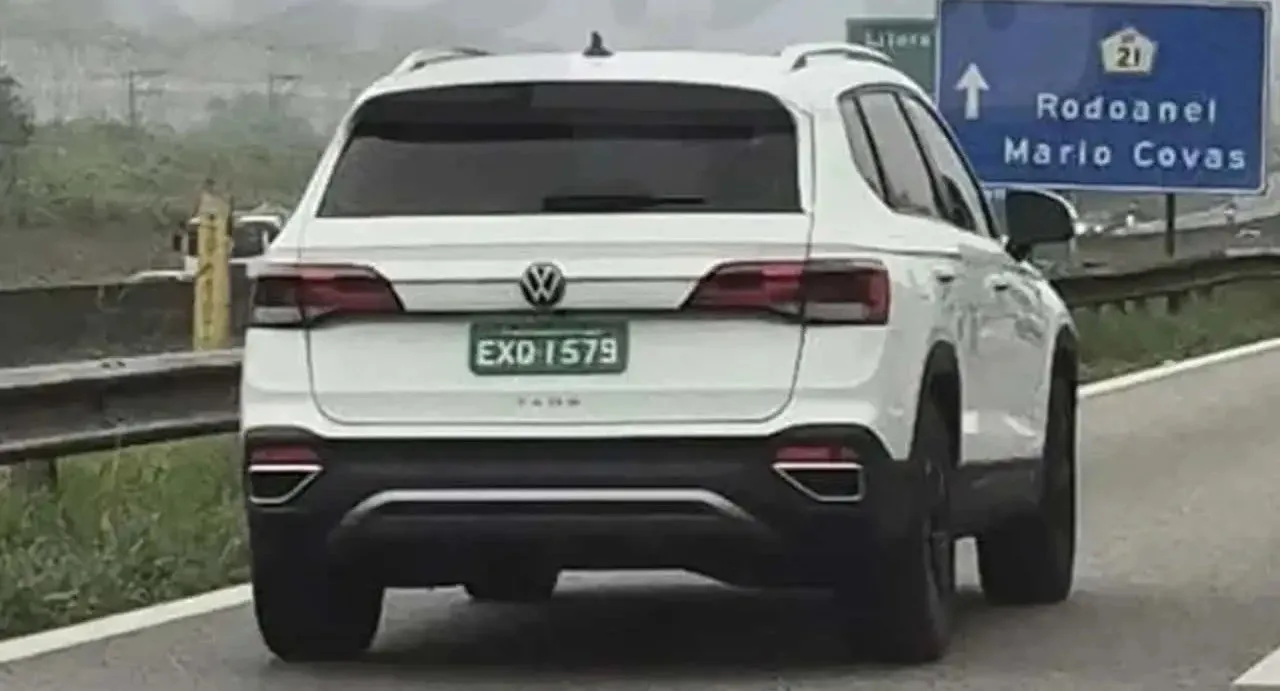Novo Volkswagen Taos branco de traseira andando na estrada