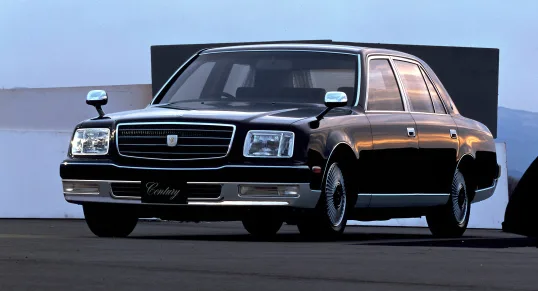 Toyota Century V12 preto parado de frente no asfalto