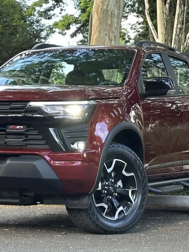 Chevrolet S10 Z71 vermelha parada de frente e lateral com árvores ao fundo