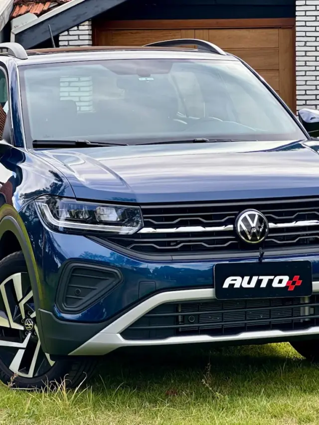 Volkswagen T-Cross Comfortline azul de frente em um gramado com uma casa ao fundo
