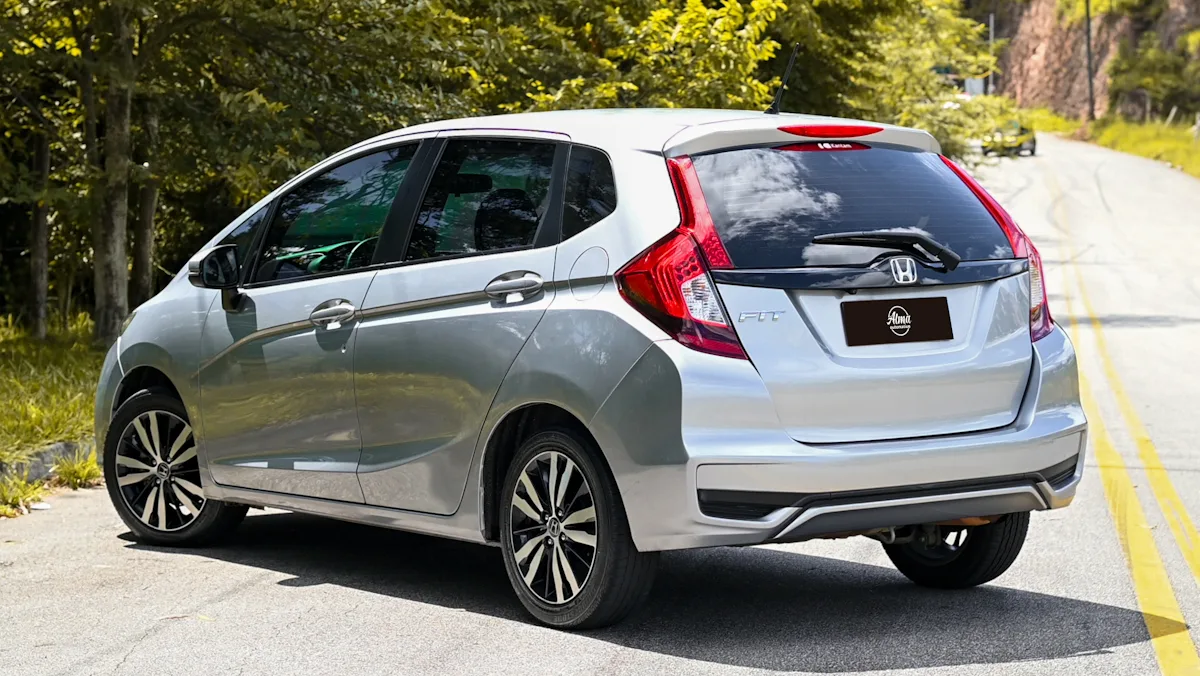 Honda Fit prata de traseira em um fundo florestal