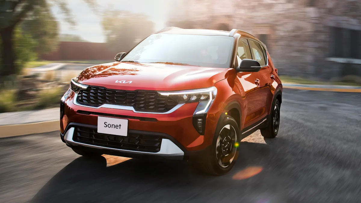 Kia Sonet vermelho de frente com uma luz forte ao fundo