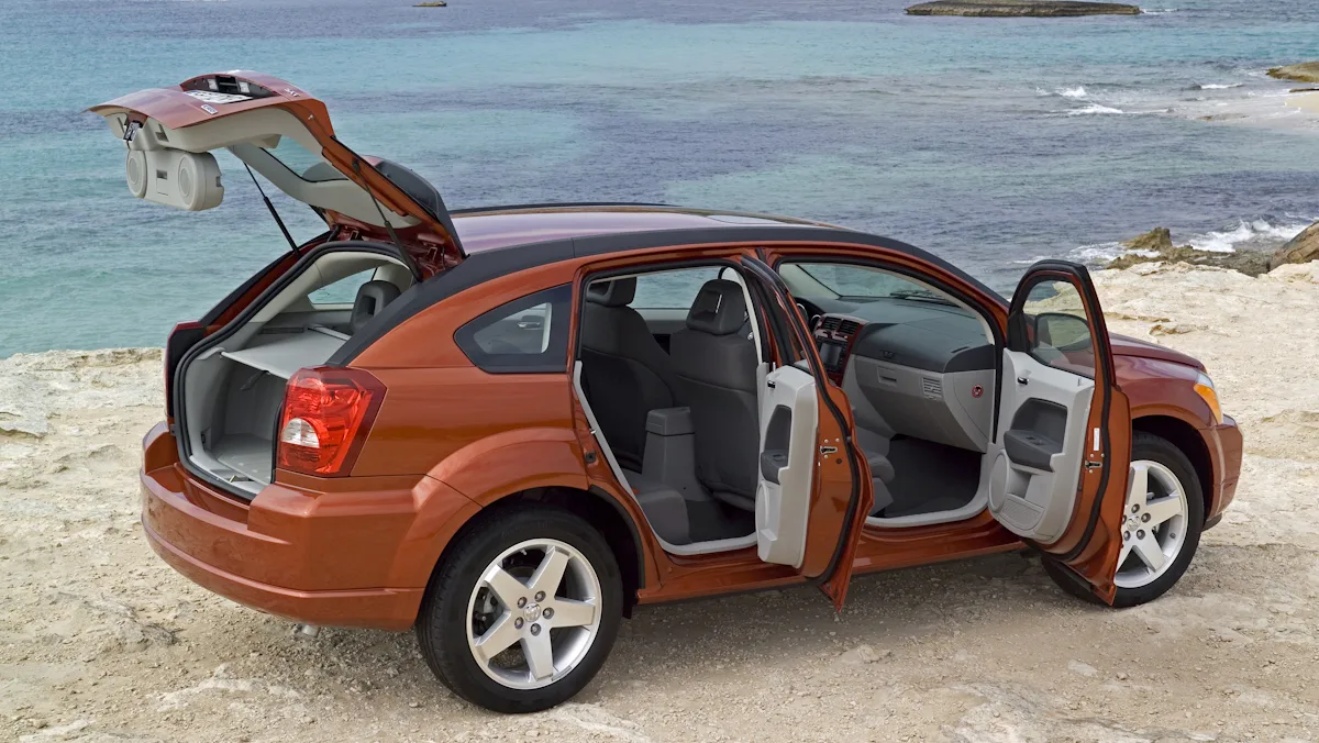 Dodge Caliber vermelho parado de traseira/lateral com as portas abertas