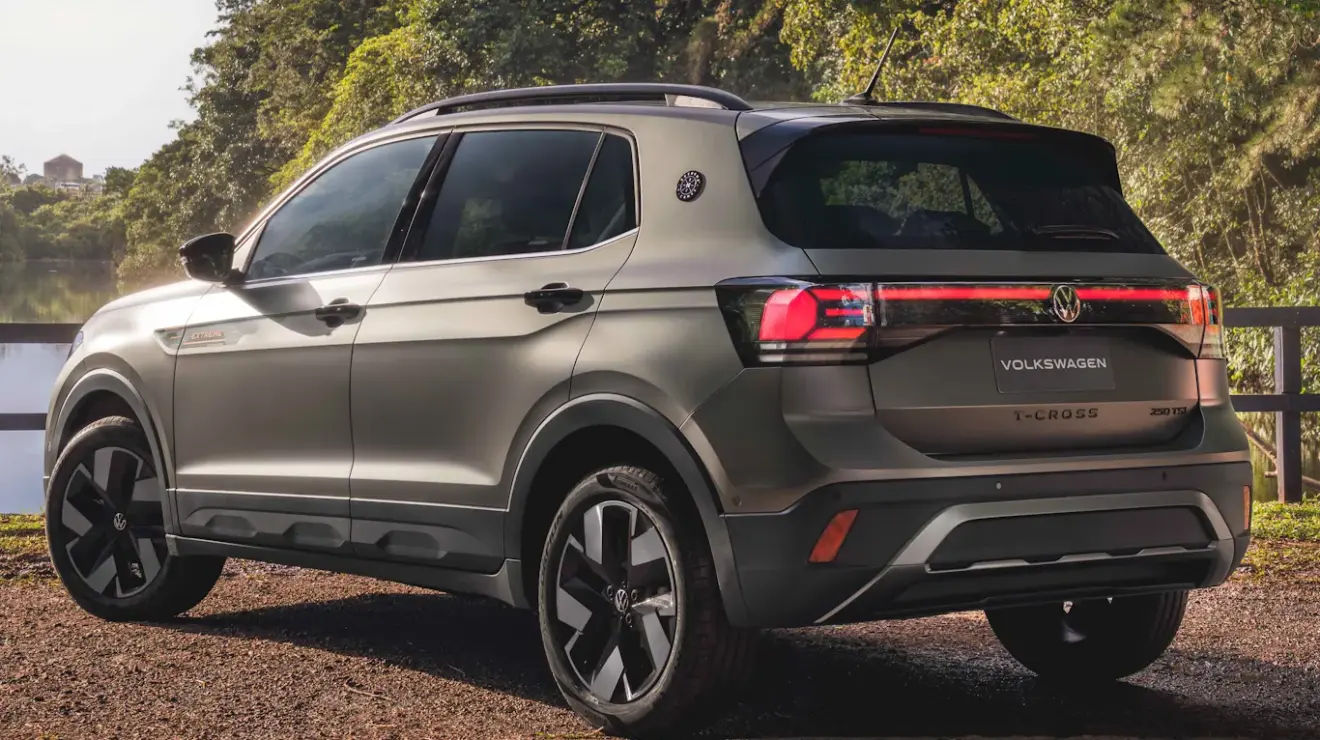 Volkswagen T-Cross Extreme cinza esverdeado, com detalhes pretos e laranja, visto de trás e com lanternas acesas