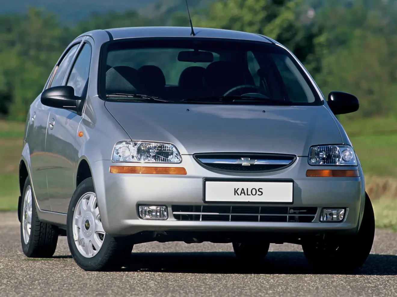 Chevrolet Kalos prata parado de frente com árvores ao fundo