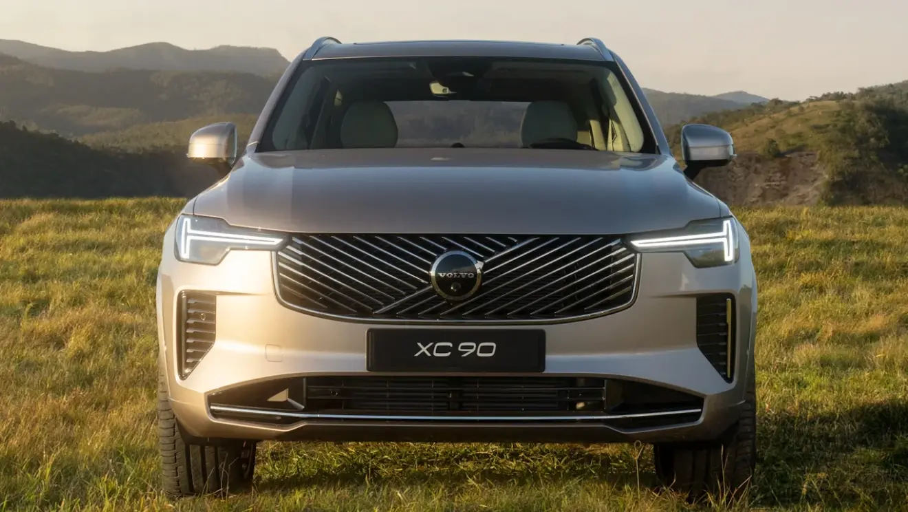 Dianteira do Volvo XC90 reestilizado bege, com faróis acesos e detalhes pretos