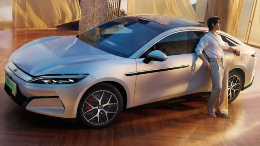 Novo BYD Han L prata com detalhes escuros, visto de cima e com homem encostado