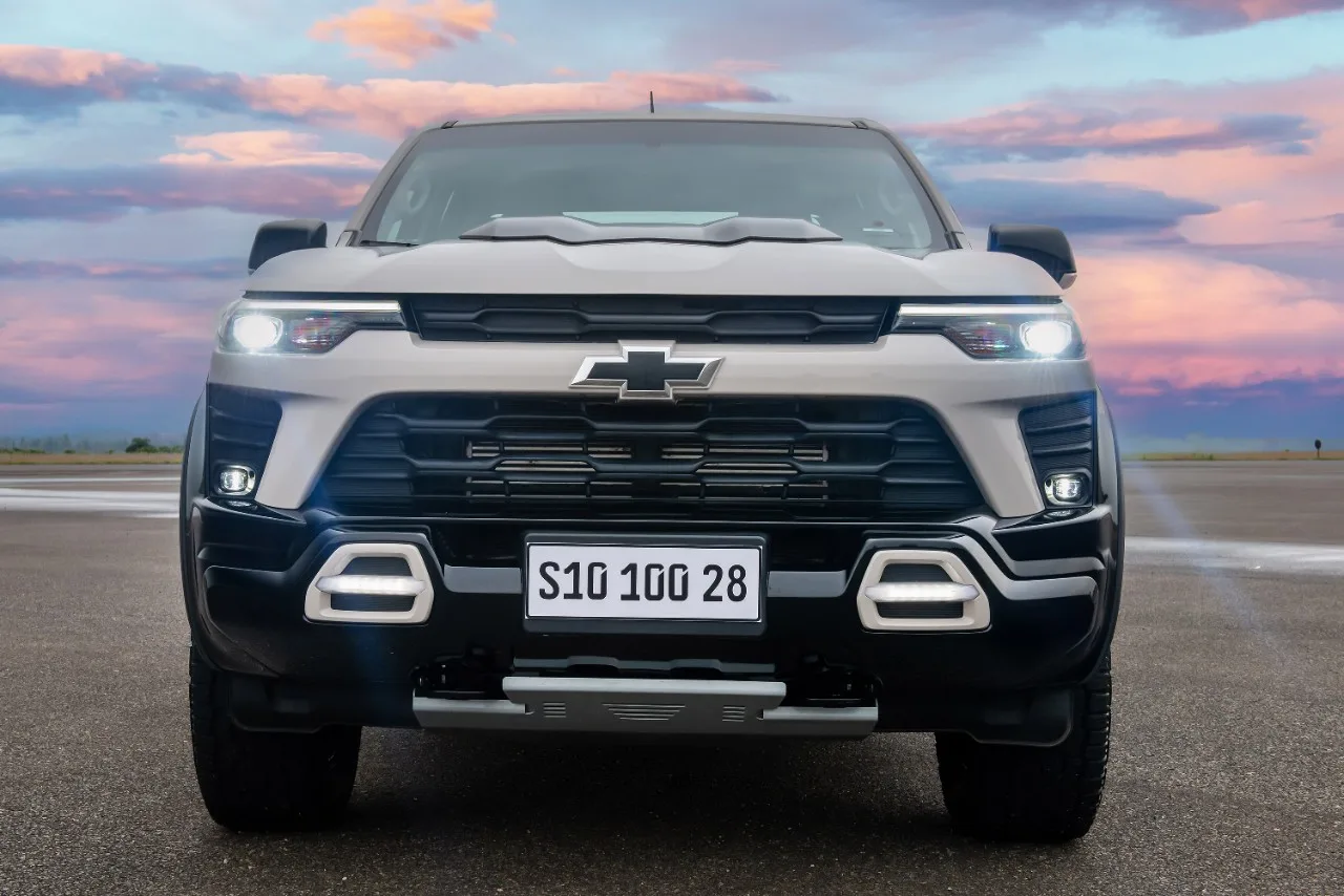 Chevrolet S10 100 anos branca com detalhes pretos, vista de frente e com faróis acesos