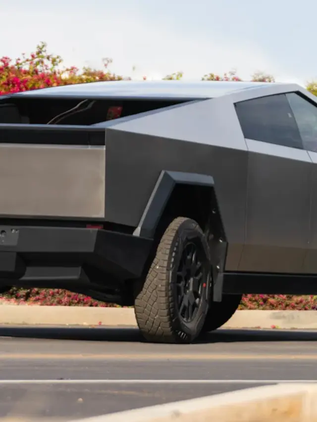 Tesla Cybertruck de frente com um muro de plantas vermelhas ao fundo