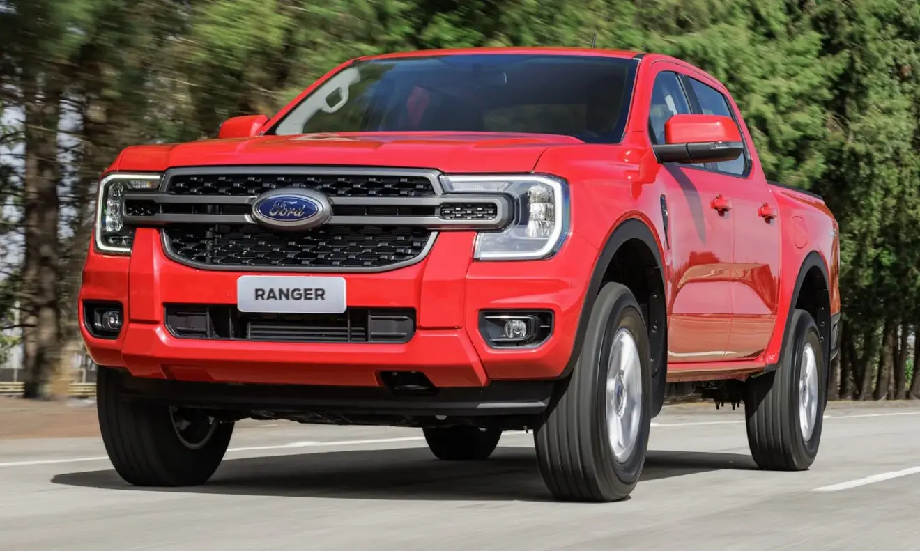 Ford Ranger XLS vermelha em movimento no asfalto com árvores ao fundo