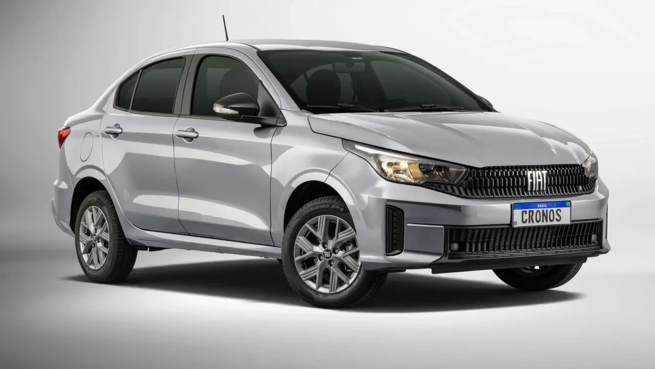 Fiat Cronos Drive 1.0 manual prata, com faróis acesos e visto de lado