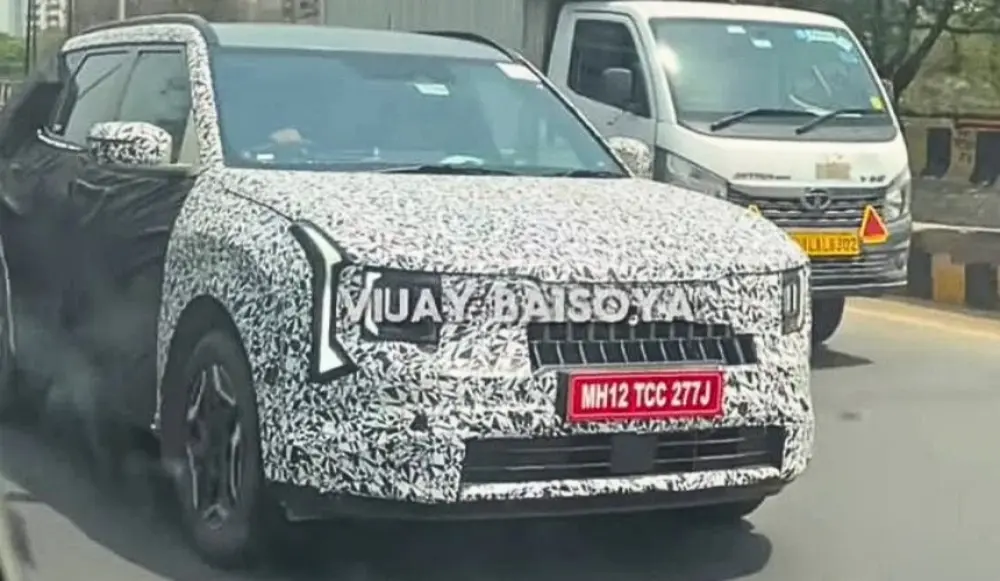 Novo Kia Seltos camuflado de preto e branco, visto de frente e com faróis acesos