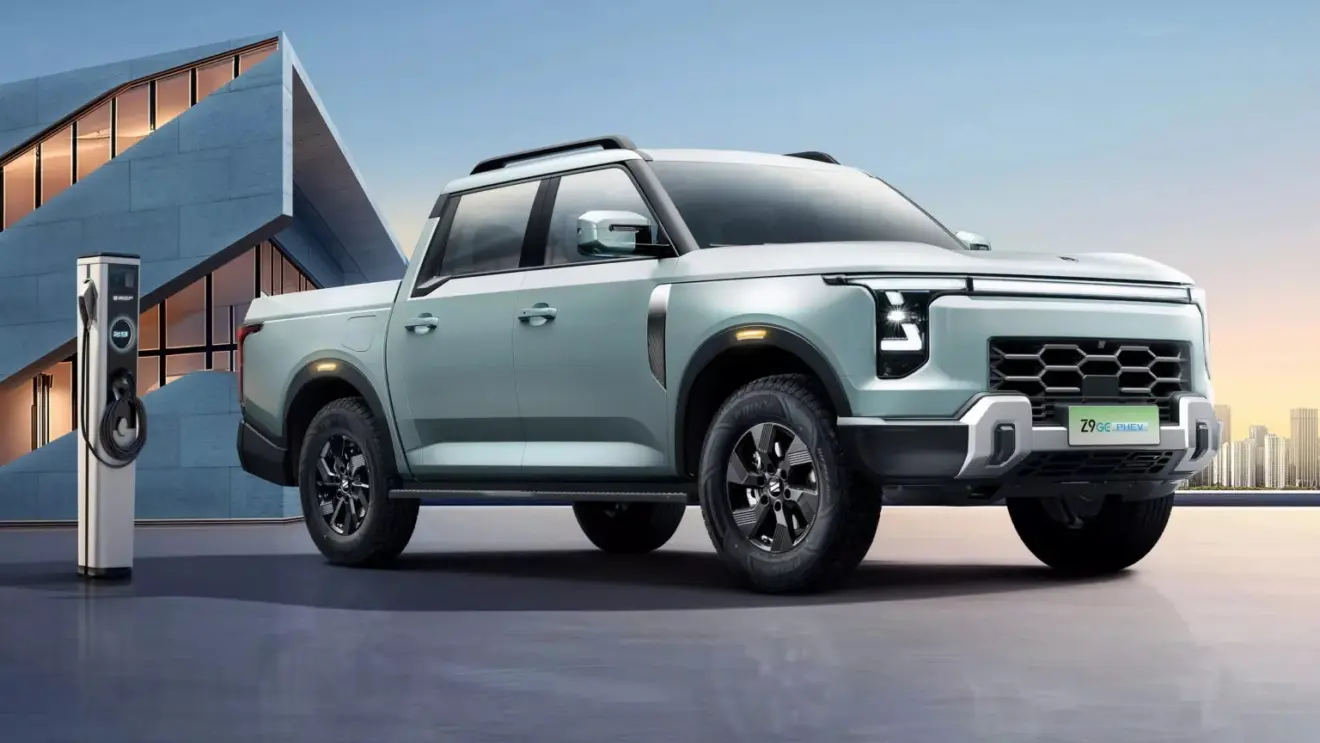 Nissan Frontier Híbrida plug-in cinza azulado com detalhes pretos, faróis acesos e vista de frente