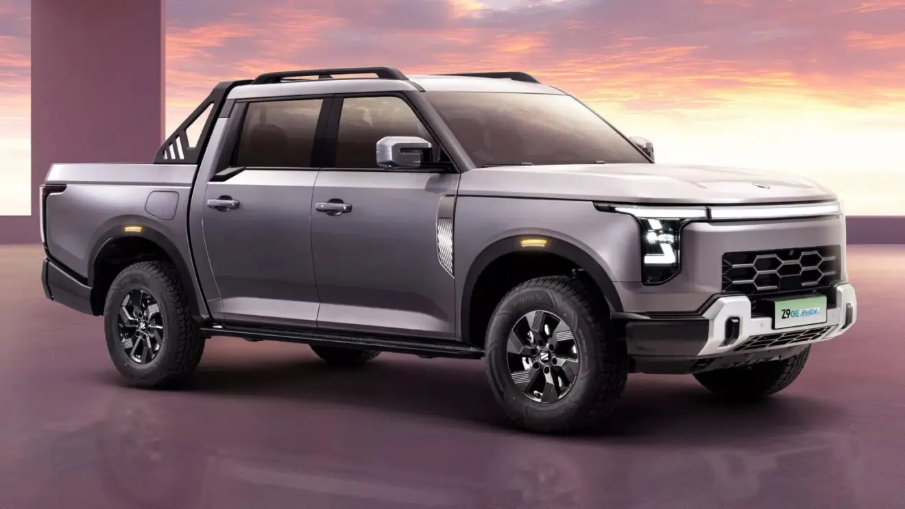 Nissan Frontier Híbrida plug-in cinza azulado com detalhes pretos, faróis acesos e vista de frente