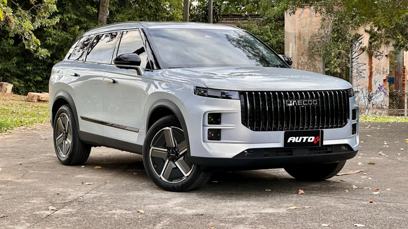 Jaecoo 7 Prestige cinza de frente a uma casa abandonada